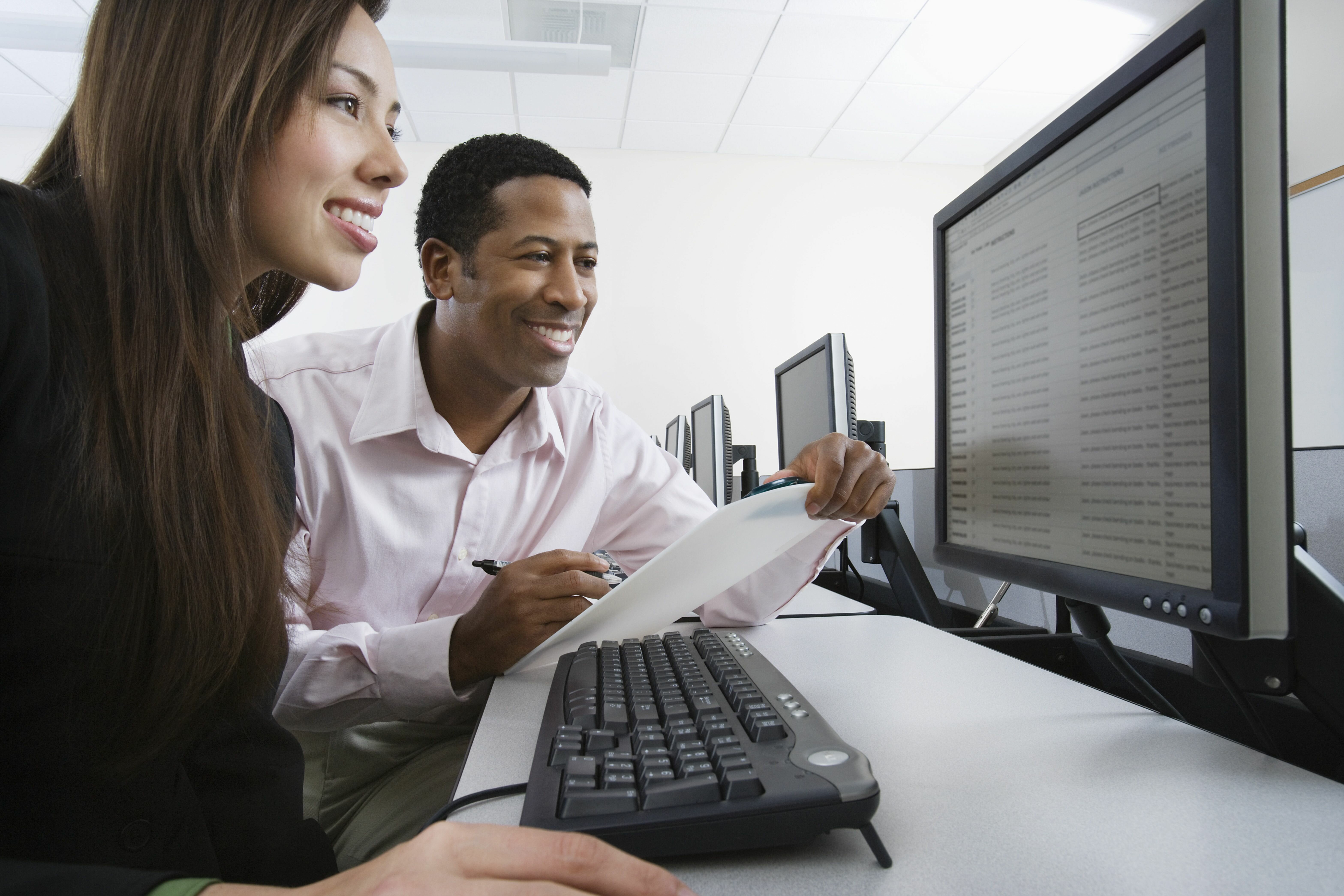 Stock photo of two people reading a computer screen