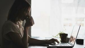 A person sits in front of their computer at home